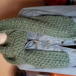Hand knit scarf made from 2 different strands of yarn in seafoam green.